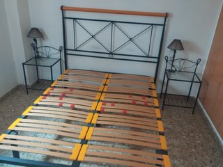 Cama con mesitas y lámparas