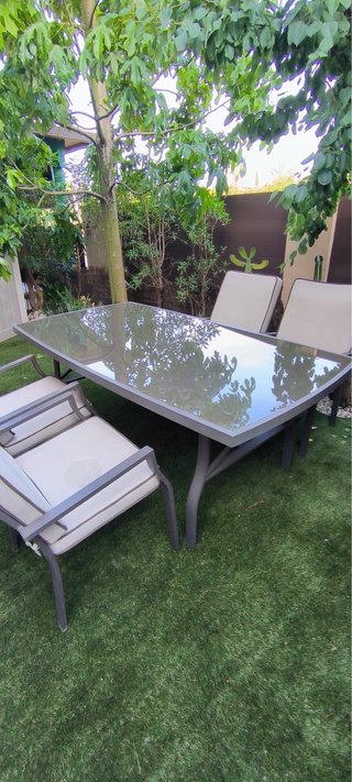 Mesa de comedor exterior de cristal y metal gris