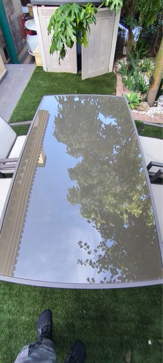 Mesa de comedor exterior de cristal y metal gris