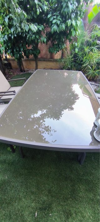 Mesa de comedor exterior de cristal y metal gris
