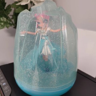 Muñeca voladora con base de cristal