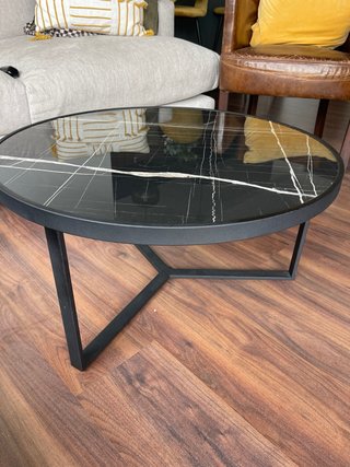 Mesa de centro redonda negra con detalles blancos