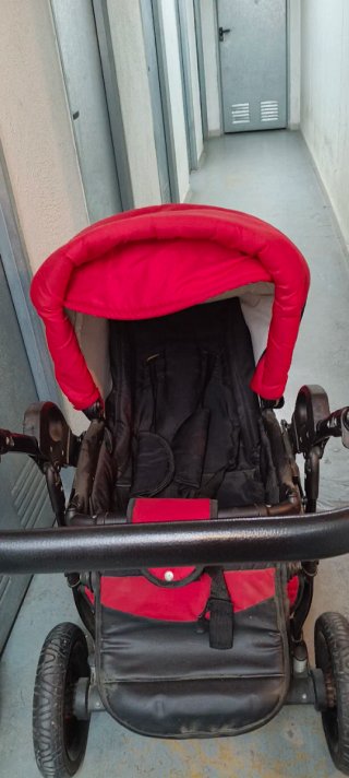 Carro de bebé rojo y negro.
