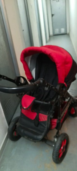Carro de bebé rojo y negro.