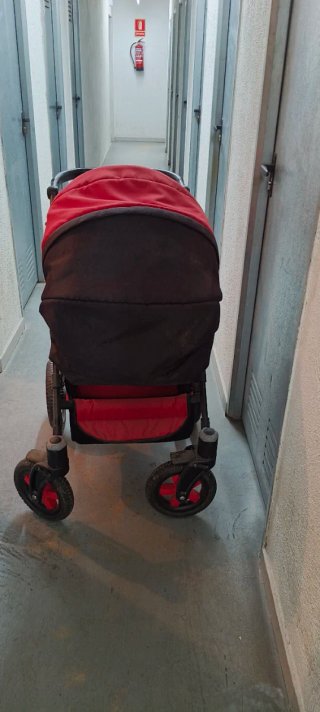 Carro de bebé rojo y negro.