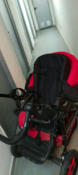 Carro de bebé rojo y negro.