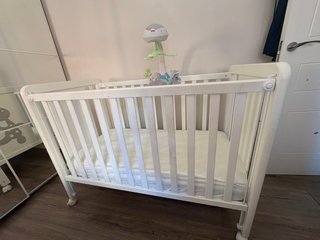 Cuna blanca con diseño de jirafa y el colchón