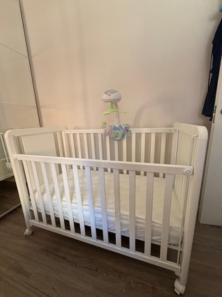 Cuna blanca con diseño de jirafa y el colchón