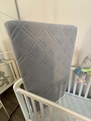 Cuna blanca con diseño de jirafa y el colchón