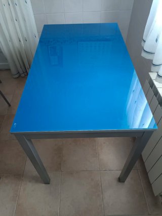Mesa cocina con cristal azul y patas de aluminio.