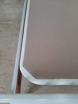 Somier tapizado en cuero beige y blanco.