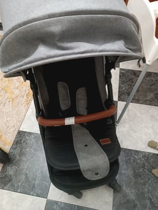Carro de bebé gris con manillar marrón
