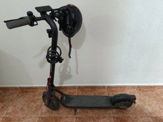 Patinete eléctrico usado, con casco y chaleco