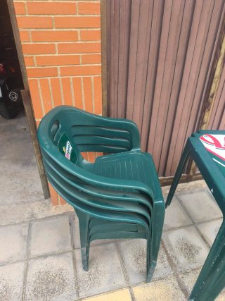 Mesa y 4 sillas de plástico. Típicas de terraza.