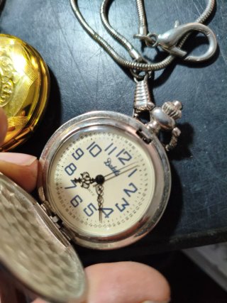 Reloj de bolsillo dorado y plateado