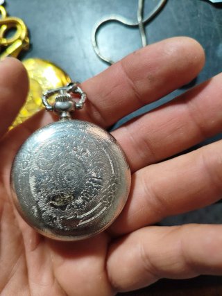 Reloj de bolsillo dorado y plateado