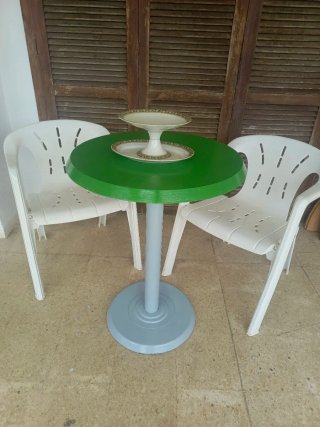 Mesa redonda verde con 2 sillas blancas