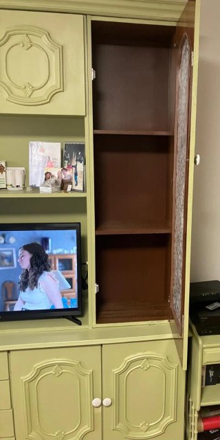 Mueble de salón verde con puertas de cristal