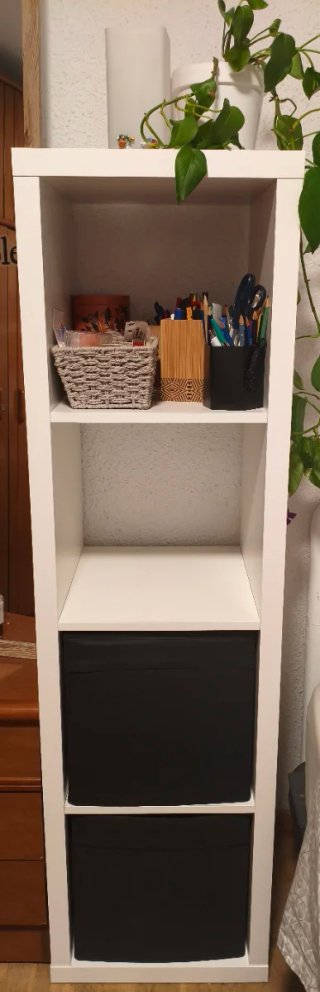 Estantería blanca con cajas negras incluídas.