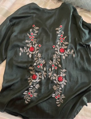 Blusa oversize verde con cremallera y bordados.