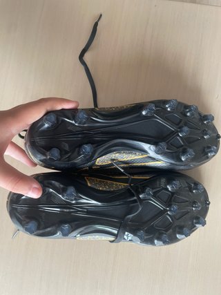 Botas de fútbol negras y doradas