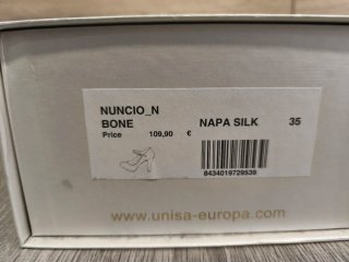 Zapatos de novia blancos con pulsera al tobillo.