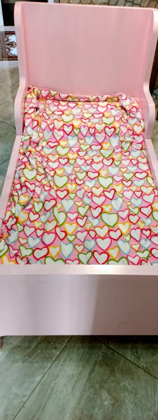 Cama infantil rosa con estampado de corazones