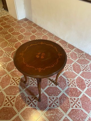 Mesa redonda de madera con marquetería