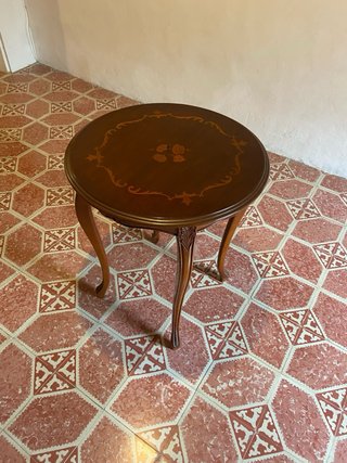 Mesa redonda de madera con marquetería