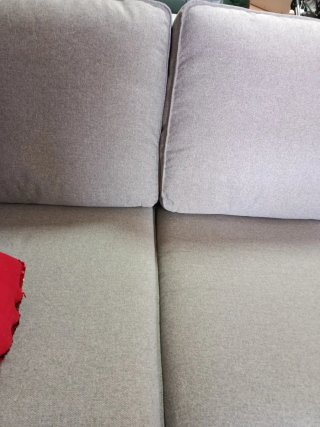 Sofá gris de tela con corazón rojo