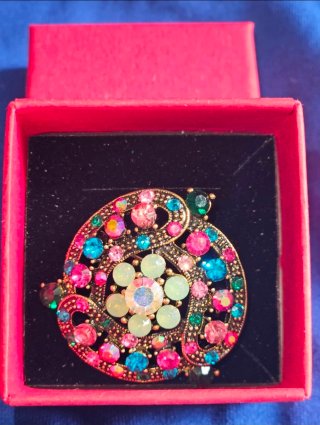 Broche dorado con piedras multicolor