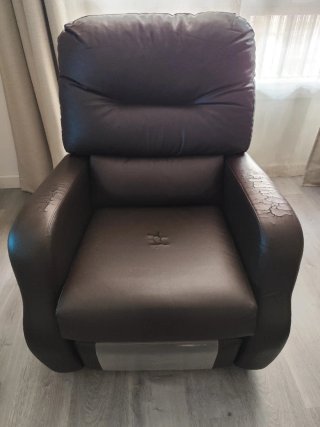 Sillón reclinable de piel sintética marrón.