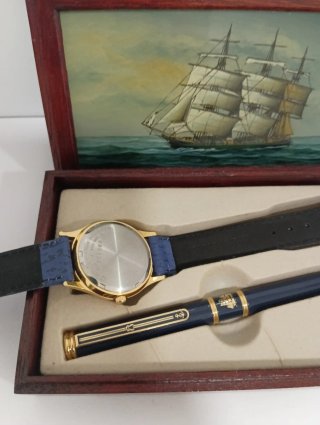 Reloj y bolígrafo en caja de madera