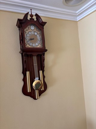 Reloj de pared de madera con péndulo .