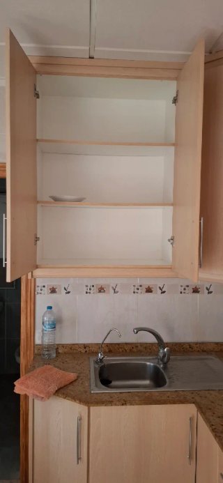 Muebles de cocina + encimera + mesa con sillas.