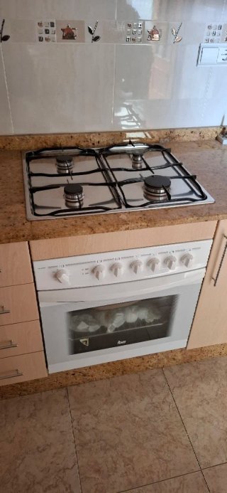 Muebles de cocina + encimera + mesa con sillas.