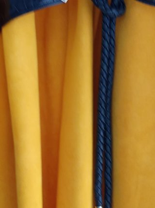 Abrigo amarillo con cinturón negro.