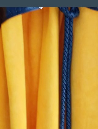 Abrigo amarillo con cinturón negro.