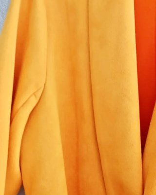 Abrigo amarillo con cinturón negro.