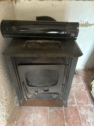 Estufa de leña negra con tubo