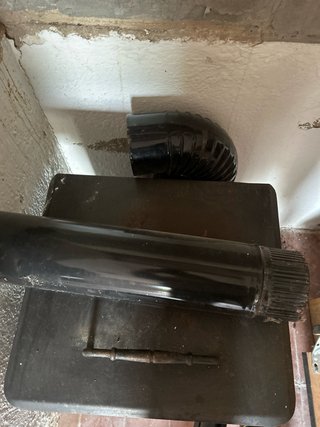 Estufa de leña negra con tubo