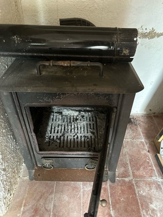 Estufa de leña negra con tubo