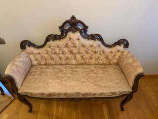 Sofá antiguo tapizado beige y madera oscura