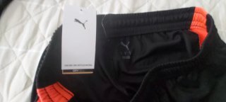 Conjunto deportivo Puma negro y naranja,etiquetado