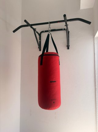 Saco de boxeo rojo con barra de dominadas.