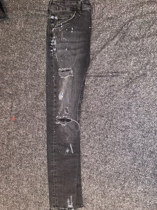 Pantalones vaqueros grises con rotos y pintura