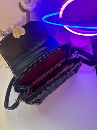 Bolso negro super mono con un corazón dorado