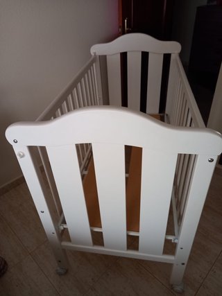 Cuna blanca con colchón Tiene arañazos típicos .
