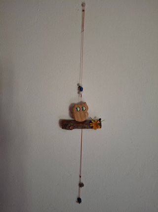Figura de búho de madera con flor