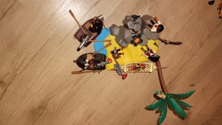 Un una isla con 4 piratas, un niño, un cofre, etc.
